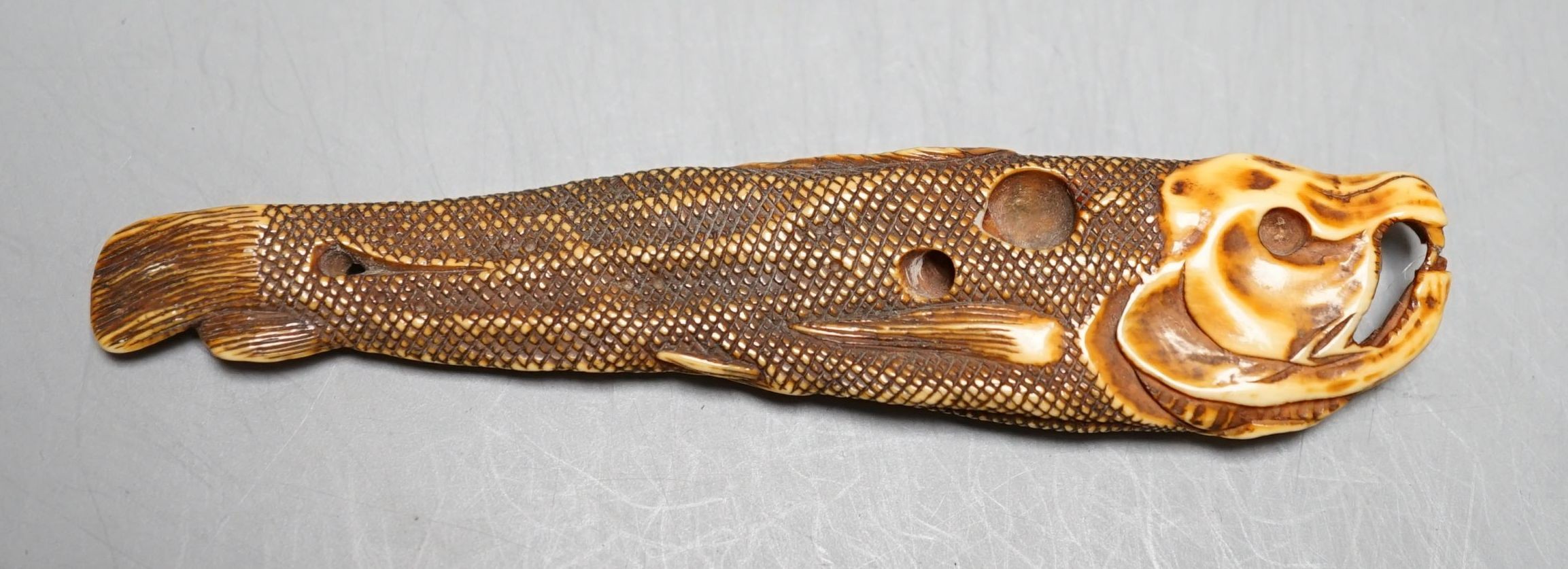 A Japanese ivory 'dried fish' netsuke, 19th century, 10cm long